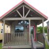 The Coyote P-561SL model by Platinum Cottages & RRC Athens. This model is shown with the standard loft & front porch. Also shown with Blue Ponderosa Pine accents. See above for the floorplan, pictures, pricing and a virtual tour of this model currently on display in Athens TX.