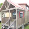 The Coyote P-561SL model by Platinum Cottages & RRC Athens. This model is shown with the standard loft & front porch. Also shown with Blue Ponderosa Pine accents. See above for the floorplan, pictures, pricing and a virtual tour of this model currently on display in Athens TX.