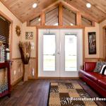 The Timberline 566SLFP model by Platinum Cottages and RRC Athens. This rustic park model cabin is shown with many upgrades including cedar interior pkg with Hickory cabs, a front porch, loft, washer/dryer front loads installed, and more!!